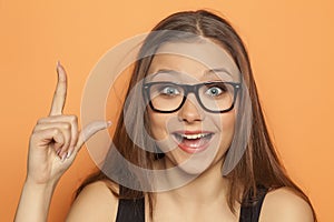 Young girl has an idea and pointing a finger upwards