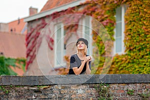 Young girl in hat at bridge in Bruges