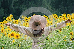 Young girl in a hat on a field of sunflowers