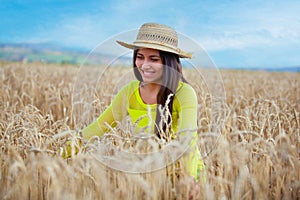 young girl in a hat in a wheat field