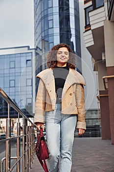 Young girl have a walk outdoors in the city near business building