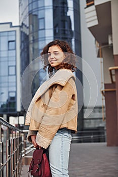 Young girl have a walk outdoors in the city near business building