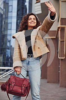 Young girl have a walk outdoors in the city near business building