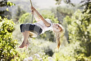 Young Girl Having Fun On Rope Swing