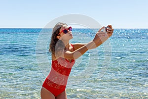 Young girl having fun taking smartphone selfie pictures of herself. travel holidays