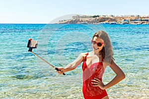 Young girl having fun taking smartphone selfie pictures of herself. travel holidays