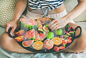 Young girl having healthy fruit breakfast in bed