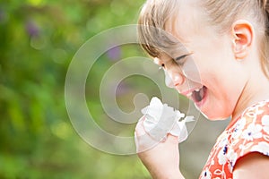 Young Girl With Hayfever Sneezing In Garden photo