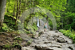 Young girl heading to Siklawica Waterfall in Strazyska Valley in Tatra Mountain range, Poland