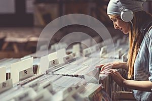Young girl with headphones browsing vinyl records