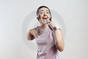 Young girl in headphones expressively sings