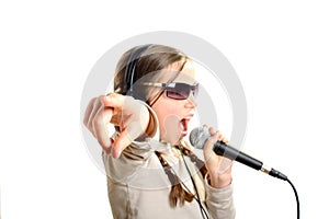 A young girl with headphones singing with a microphone
