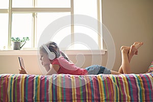 Young girl with headphones and tablet