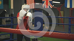 Young girl in a helmet and gloves is training blows. Closeup