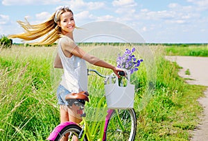 Young girl with her bike outdoors