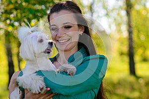 Young girl with her dog. Puppy white dog is running with it`s owner. Concept about friendship, animal and freedom