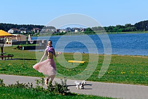 Young girl with her dog. Puppy white dog is running with it`s owner. Concept about friendship, animal and freedom