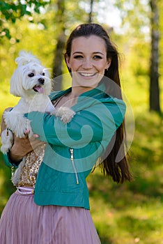 Young girl with her dog. Puppy white dog is running with it`s owner. Concept about friendship, animal and freedom