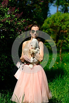 Young girl with her dog. Puppy white dog is running with it`s owner. Concept about friendship, animal and freedom