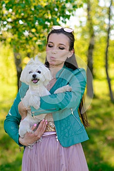 Young girl with her dog. Puppy white dog is running with it`s owner. Concept about friendship, animal and freedom