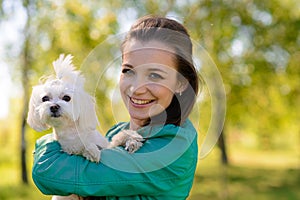 Young girl with her dog. Puppy white dog is running with it`s owner. Concept about friendship, animal and freedom