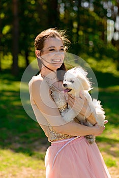 Young girl with her dog. Puppy white dog is running with it`s owner. Concept about friendship, animal and freedom
