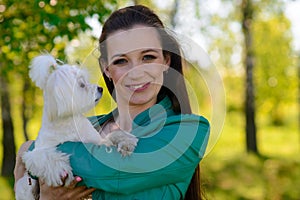 Young girl with her dog. Puppy white dog is running with it`s owner. Concept about friendship, animal and freedom