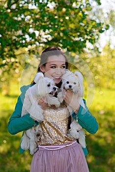 Young girl with her dog. Puppy white dog is running with it`s owner. Concept about friendship, animal and freedom