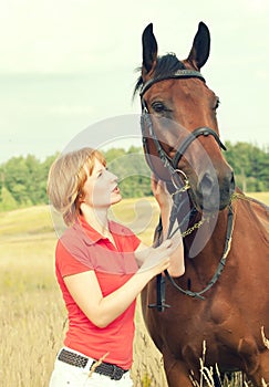 Young girl with her horse in field