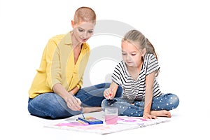 Young girl and her therapist in child occupational therapy session painting with watercolors. Child therapy concept.