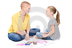 Young girl and her therapist in child occupational therapy session painting with watercolors. Child therapy concept.