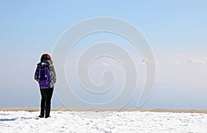 young girl hiker on the top of the mountain admires the panorama