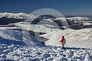 Young girl hiking outside in winter mountains