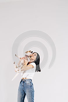 Young girl with his dog at studio. Young owner hugs his pet. young and beautiful girl holding her dog in her arms with