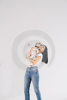 Young girl with his dog at studio. Young owner hugs his pet. young and beautiful girl holding her dog in her arms with