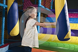 Young girl hitting foam object in play gym