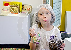 Young girl holding bags of candy at candy factory tour