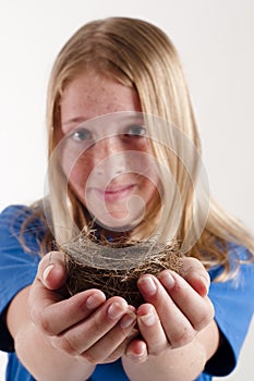 Young girl holding birds nest