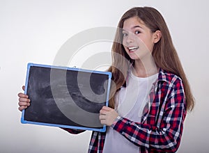 Young girl holding blackboard with copy space and advertises something. photo