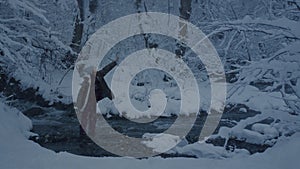 young girl holding a burning signal fire. A woman in a winter forest starts a red rescue flare