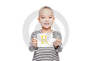 Young girl holding a card with letter R. Speech therapy concept on white background. Correct pronounciation and articulation.
