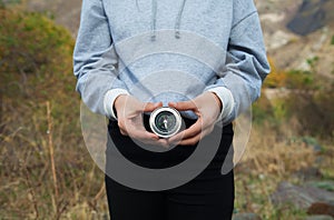 Young girl holding a compass in her hand. He is in the high mountains