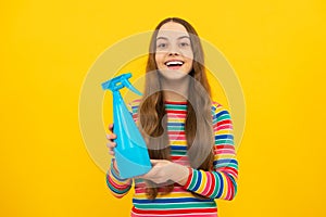 Young girl holding detergent bottle. Happy kid hold disinfectant spray product in bottle for copy space yellow