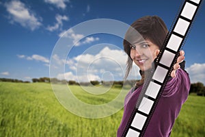 Young girl holding film strip outdoors