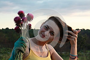 A young girl holding a flower - milk thistle, bouquet