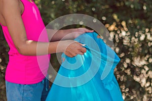 Young girl holding a package for rubbish in the park