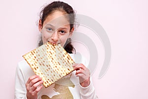 Young girl holding matzah or matza. Jewish holidays Passover invitation or greeting card.Selective focus.Copy space. photo