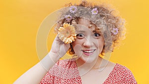 Young Girl Holding Orange Daisy Flower - Isolated Over Bright Yellow Background