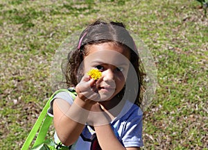 Young girl holding out yellow flower