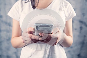 A young girl holding a phone in her hands